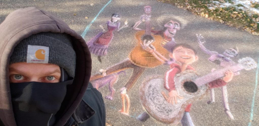 Artist Frost Simula with a Dia de los Muertos chalk art piece he created for the Columbia Heights Chalk Art Walk in Huset Park in October 2020.