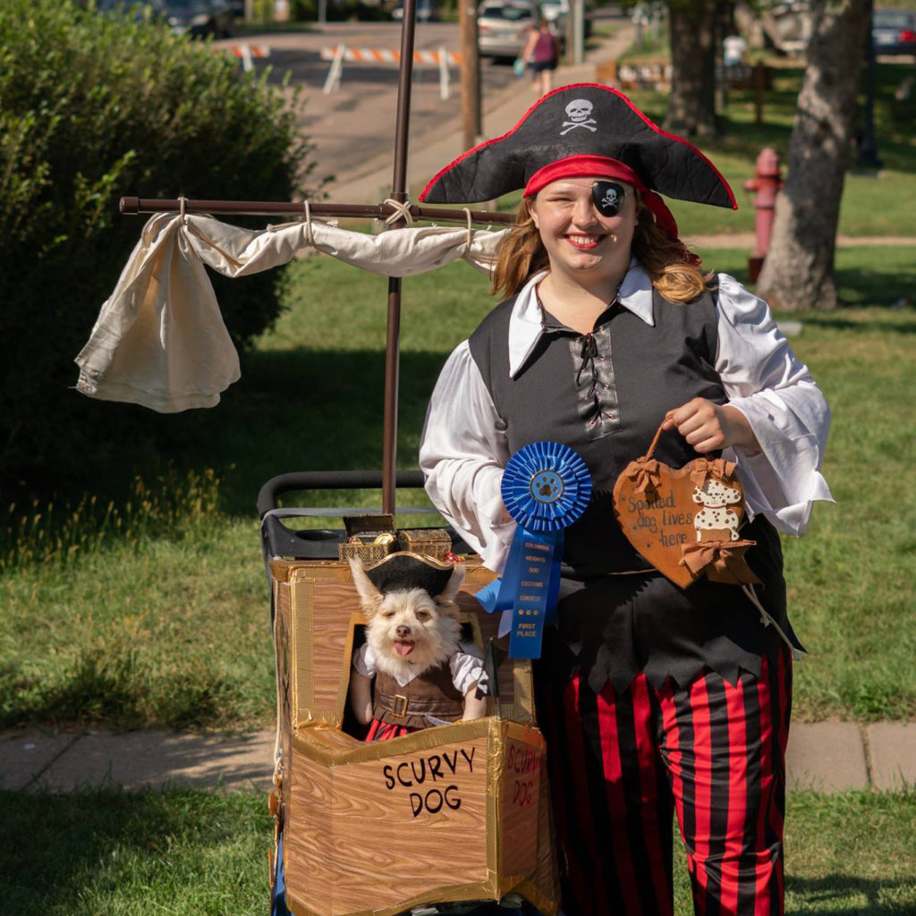 Dog and owner in a costume contest both dressed a pirates.