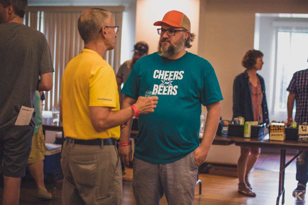 Two people talking at a beer tasting event.