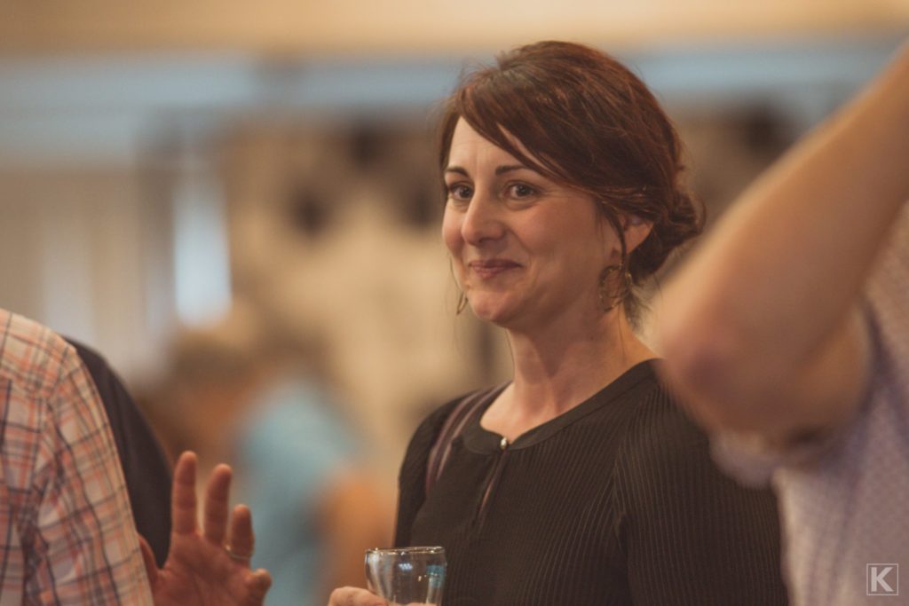 A smiling woman at a beer tasting event.