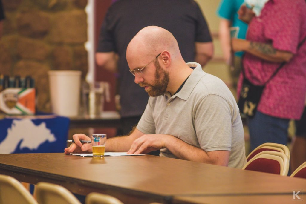 A beer critic takes notes at a beer tasting event.