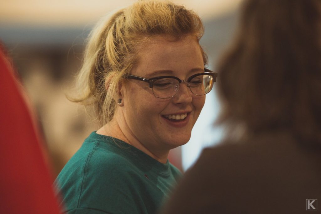 A smiling woman at a beer tasting event.