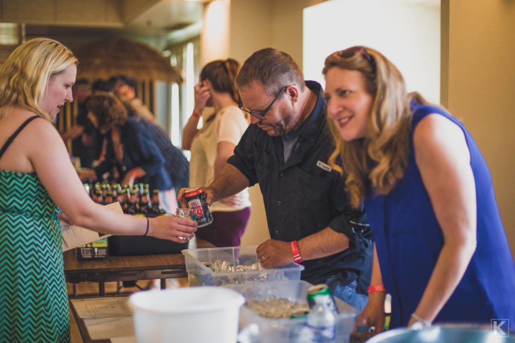 Brewers pouring beer samples for people.