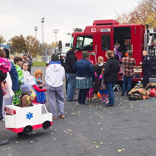 Kids in Halloween costumes line up to se the inside of a fire engine at the Columbia Heights Truck or Treat event.