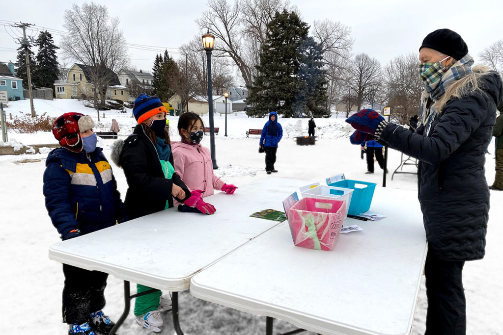Kids at a winter festival play an educational game about recycling.