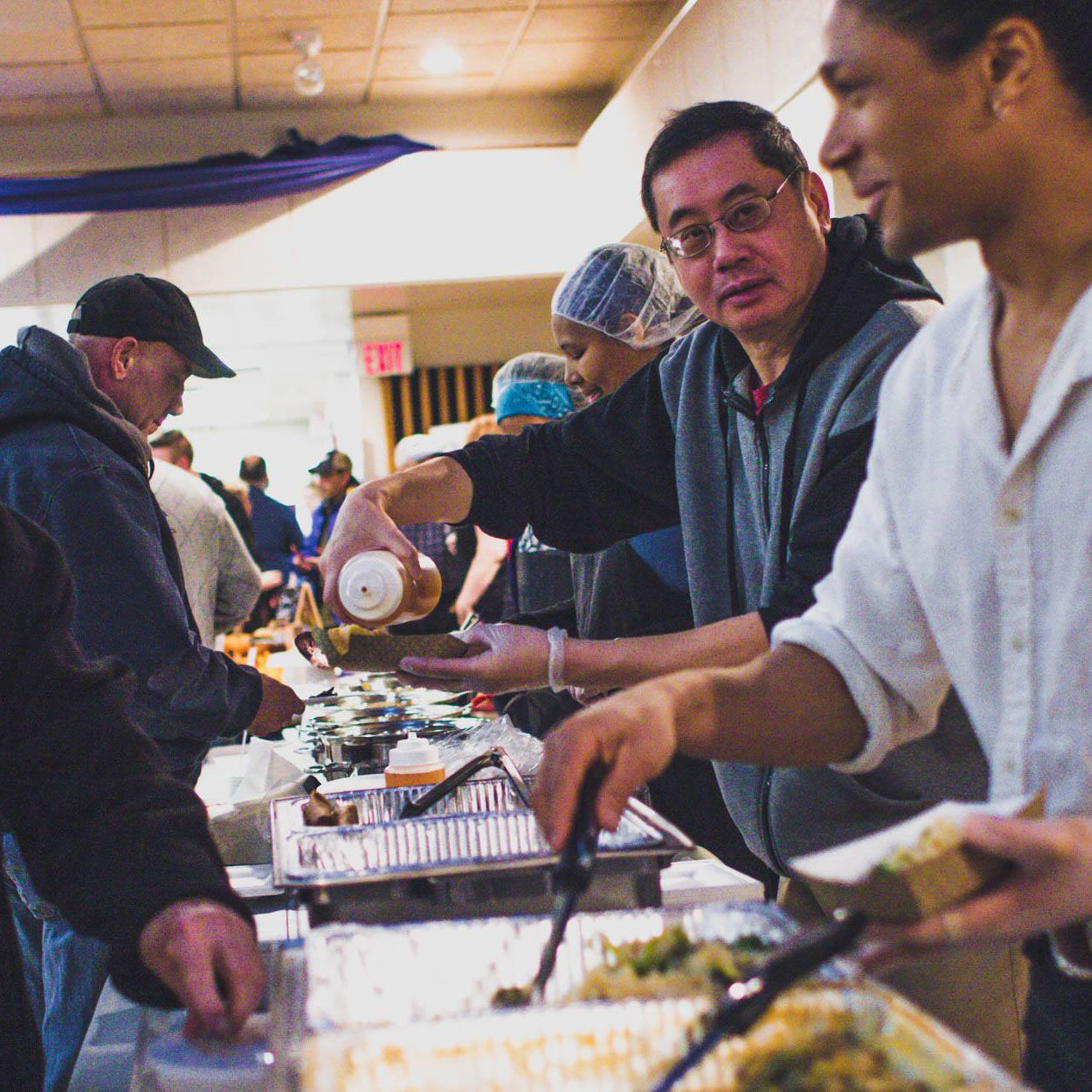 Culturally diverse restaurant workers serve samples of their cuisine to Columbia Heights, MN residents.