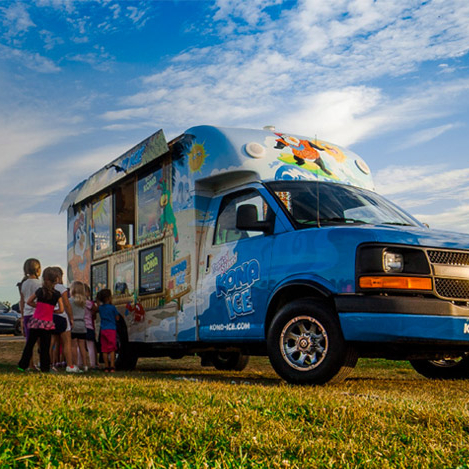 Kids lining up outside a Kona Ice Cream truck.